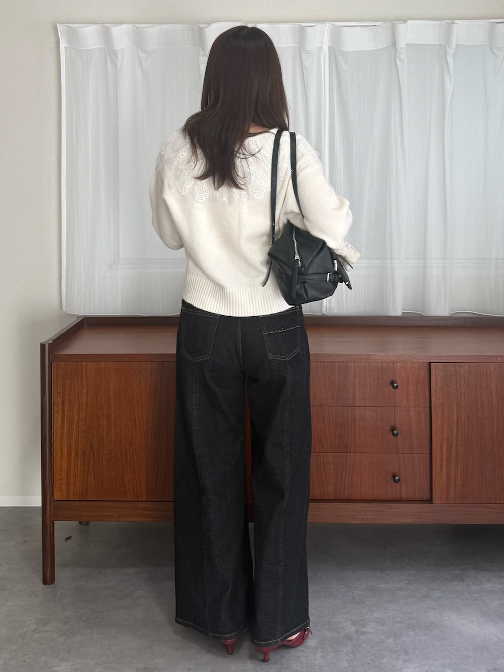 ホワイト系のカーディガン/ボレロ、ブラック系のデニムパンツ、レッド系のパンプスを着用したレディースの秋コーディネートの3枚目の写真
