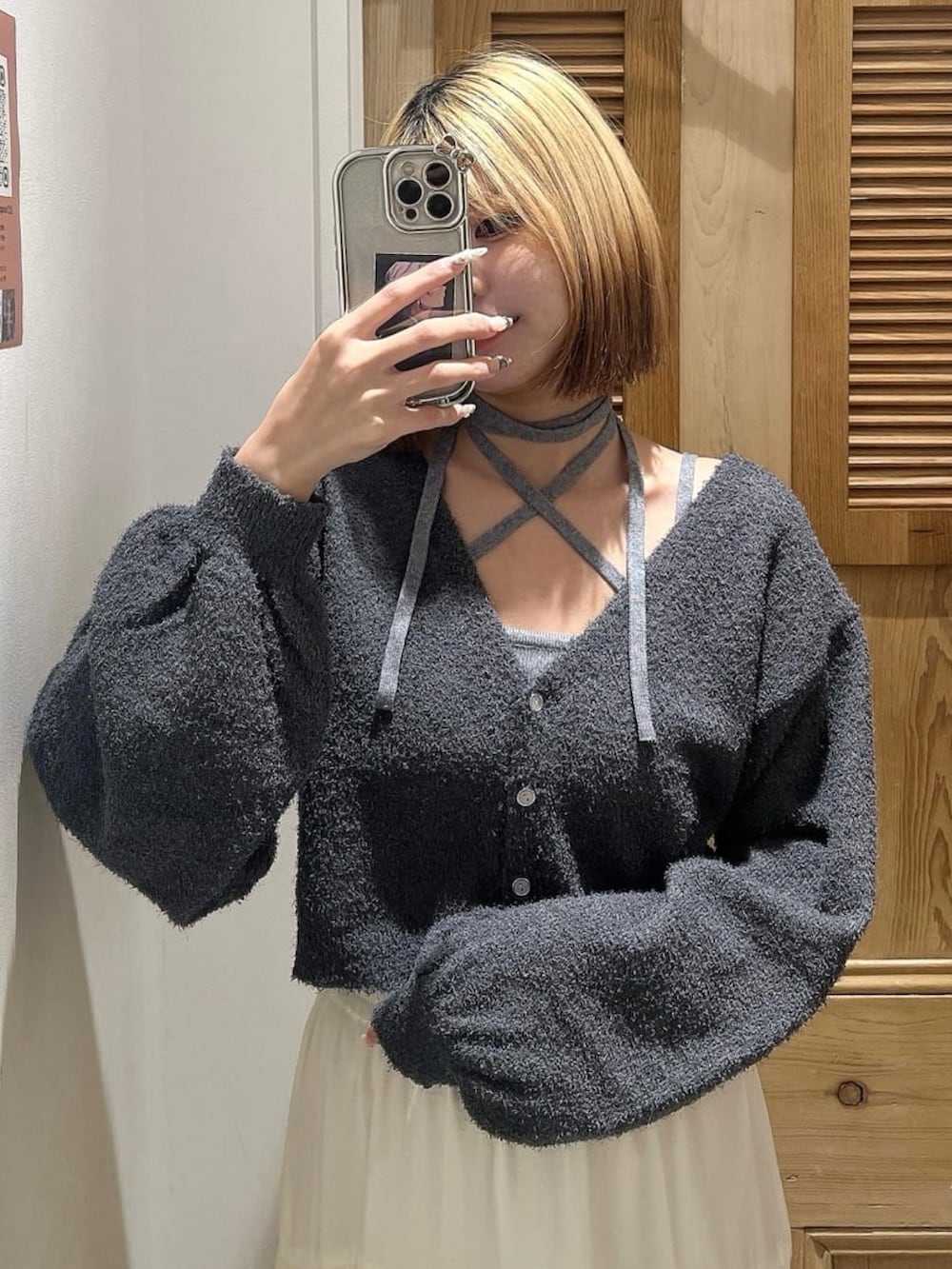 ホワイト系のスカート、グレー系のニット/セーター、ブラック系のショルダーバッグを着用したレディースの冬コーディネートの3枚目の写真