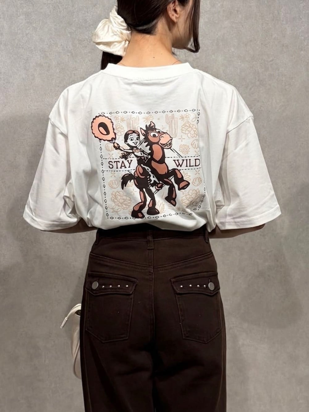 ホワイト系のTシャツ/カットソー、レッド系のTシャツ/カットソー、ブラウン系のデニムパンツを着用したレディースの夏コーディネートの4枚目の写真