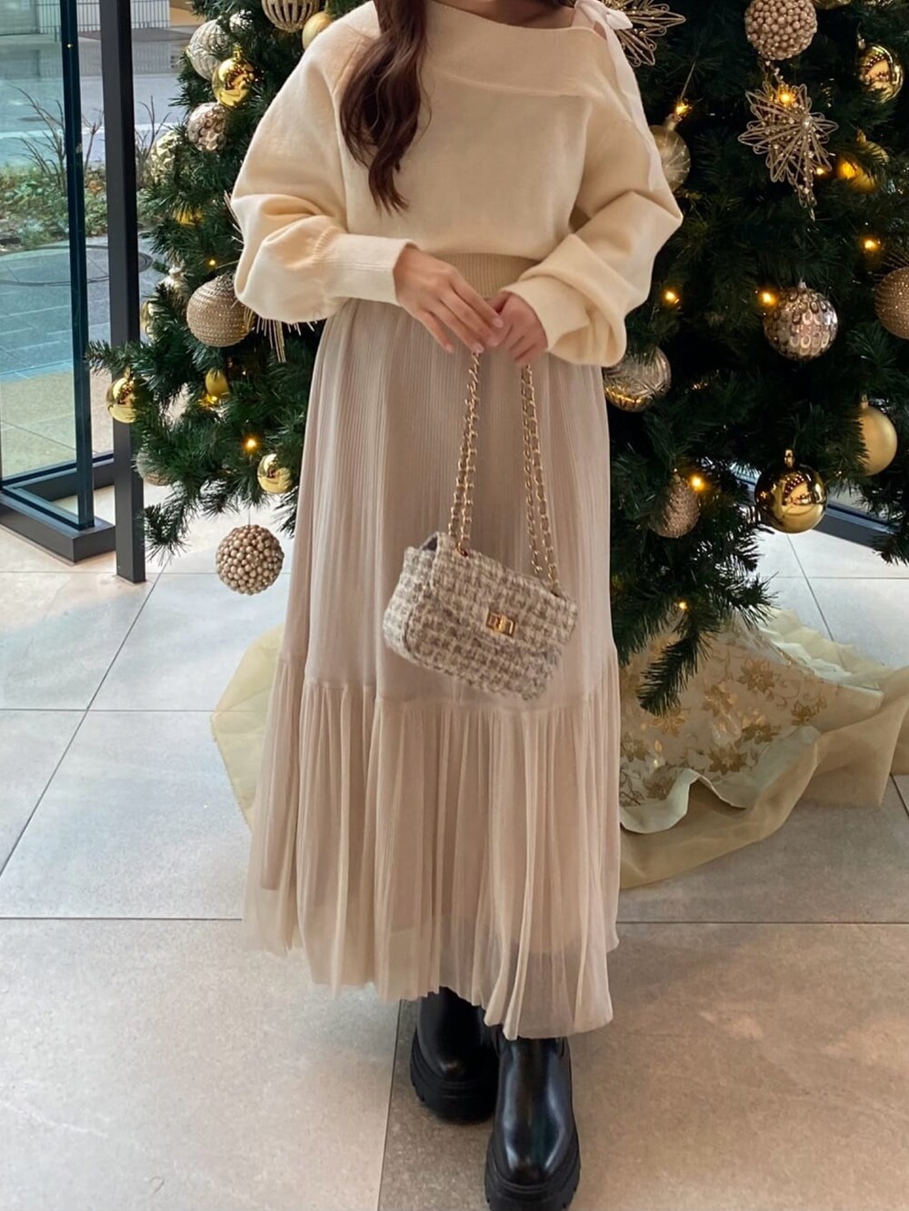 ホワイト系のニット/セーター、ホワイト系のショルダーバッグ、ホワイト系のスカートを着用したレディースの冬コーディネートの2枚目の写真