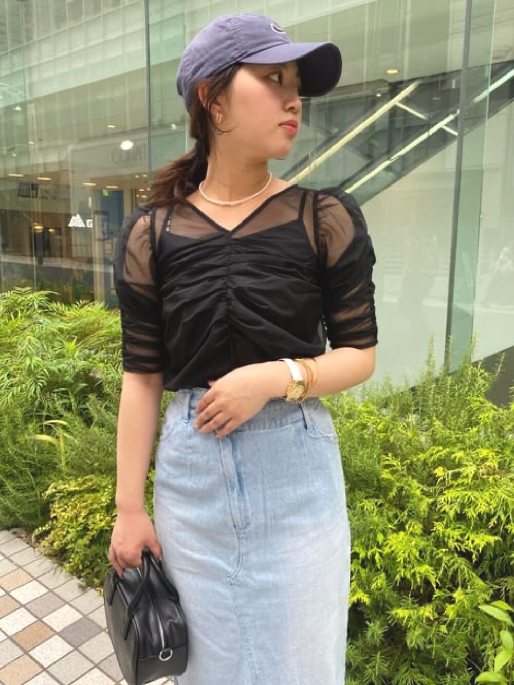 ブラック系のTシャツ/カットソー、ブルー系のデニムスカートを着用したレディースの夏コーディネートの2枚目の写真