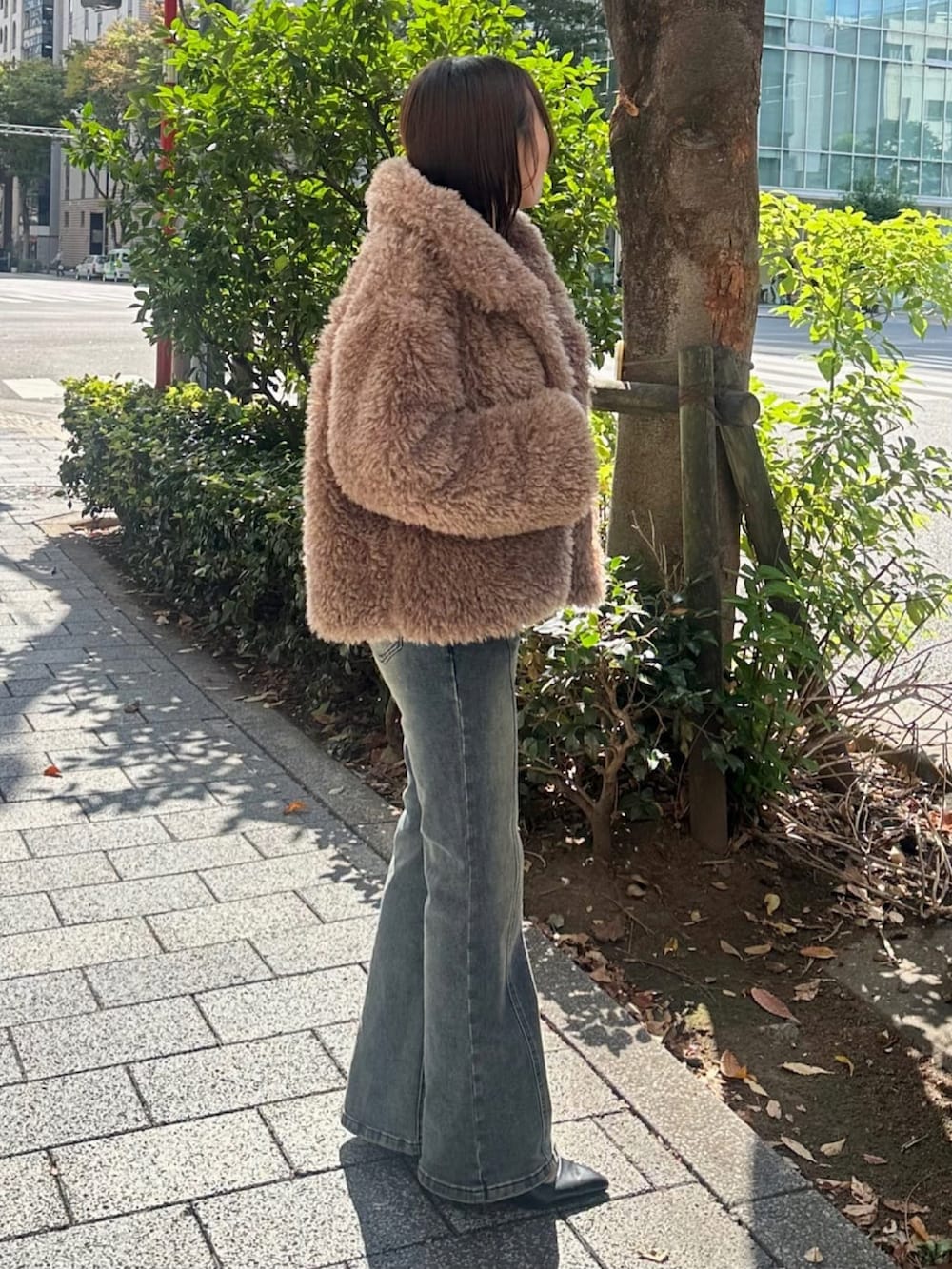 ブラウン系のブルゾン、ブルー系のデニムパンツ、ホワイト系のニット/セーターを着用したレディースの秋コーディネートの2枚目の写真