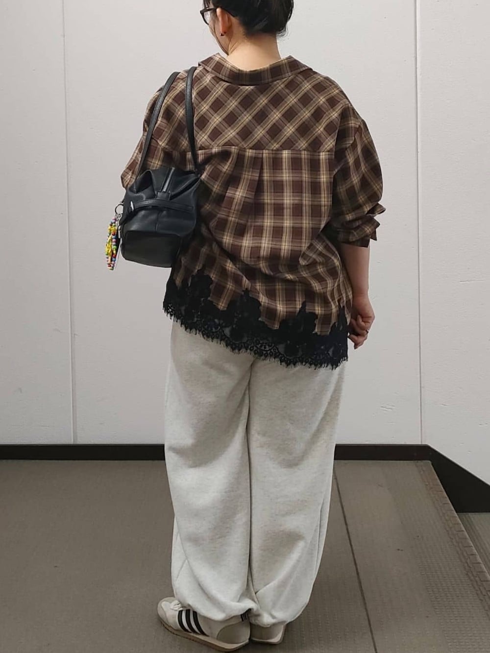 ブラウン系のシャツ/ブラウス、ベージュ系のスウェットパンツ、ブラック系のボストンバッグを着用したレディースの秋コーディネートの3枚目の写真