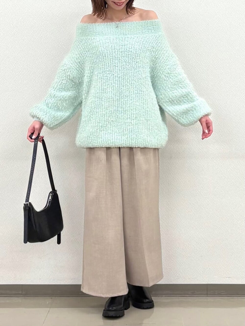 グリーン系のニット/セーターを着用したレディースの冬コーディネートの3枚目の写真