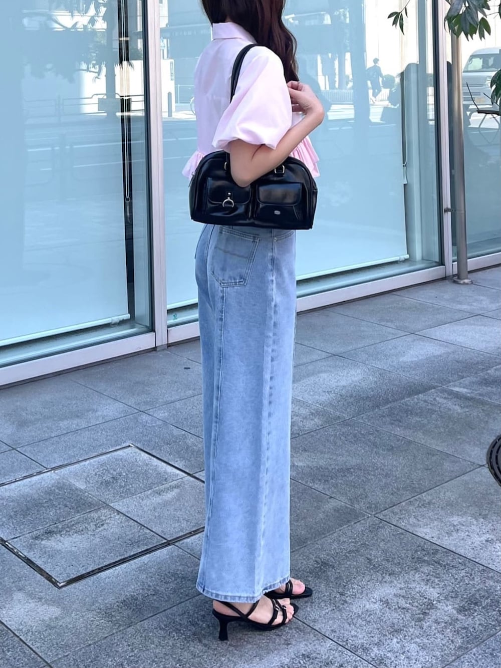 ブルー系のデニムパンツ、ピンク系のシャツ/ブラウス、ブラック系のボストンバッグを着用したレディースの夏コーディネートの2枚目の写真