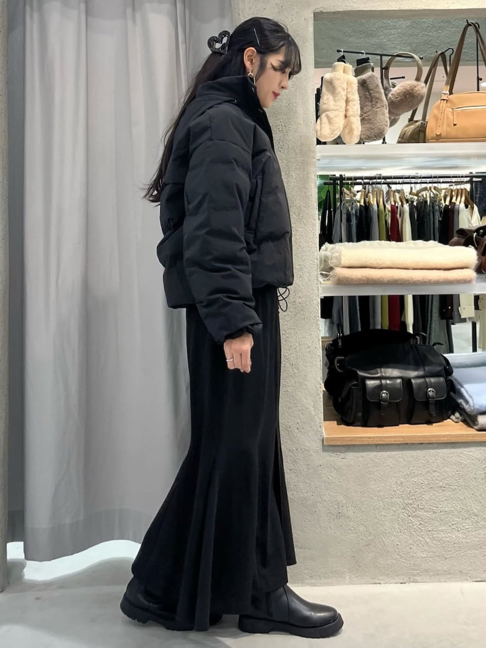 レッド系のニット/セーター、ブラック系のダウンジャケット/コート、ブラック系のスカートを着用したレディースの冬コーディネートの2枚目の写真