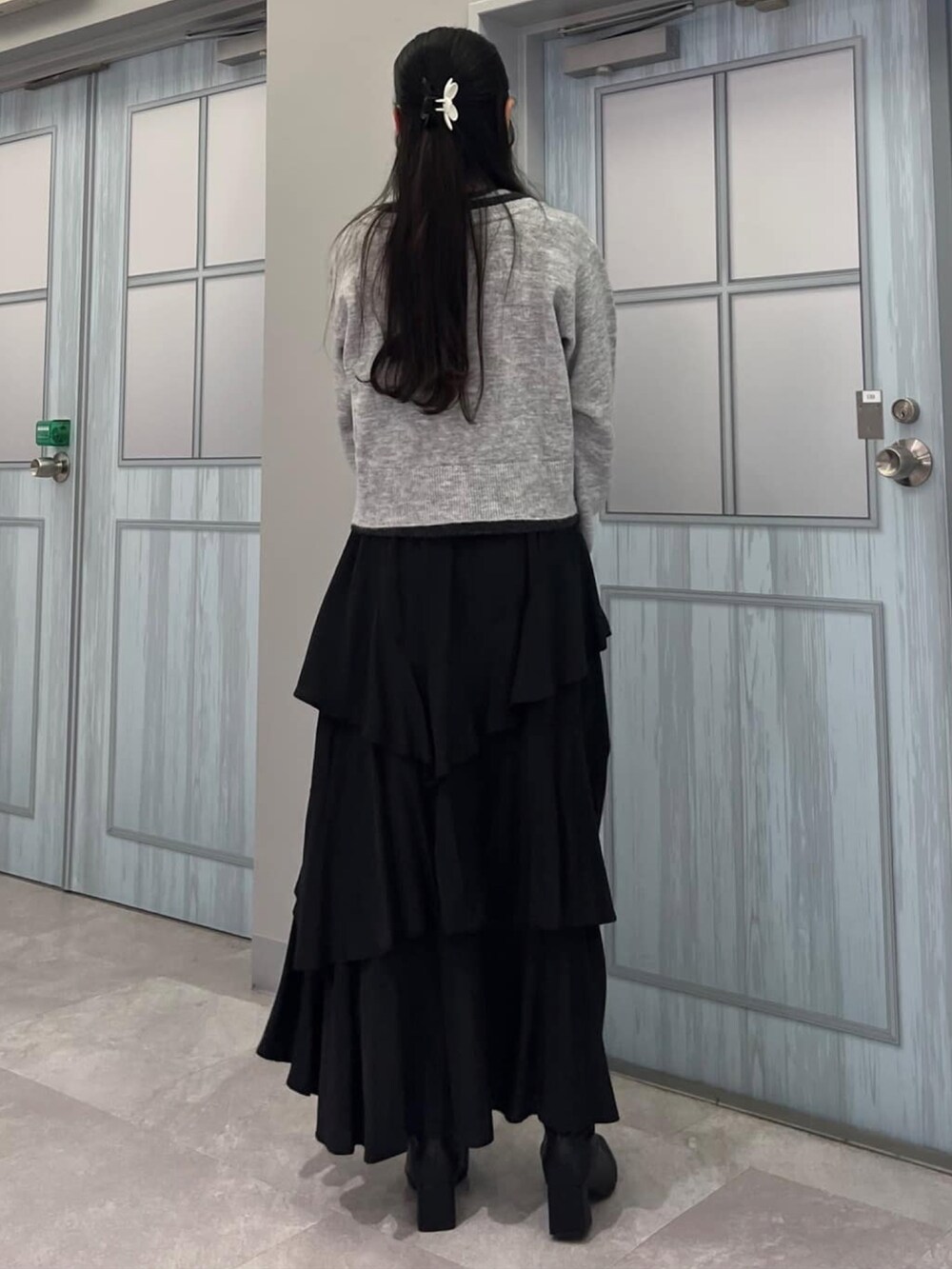 グレー系のアンサンブル、ブラック系のスカートを着用したレディースの秋コーディネートの3枚目の写真