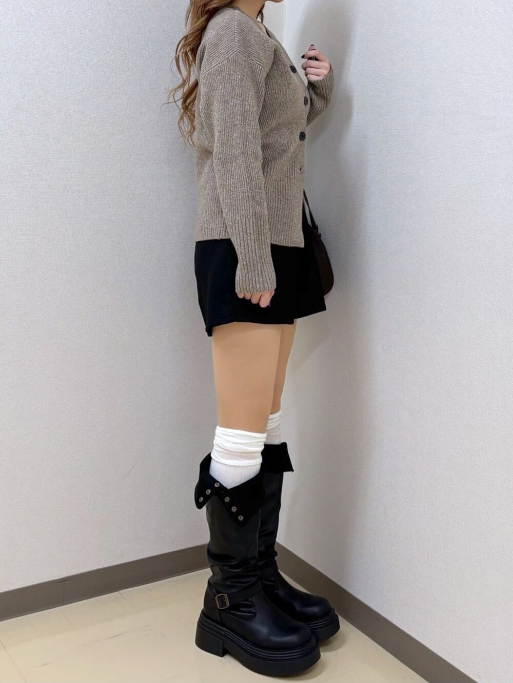 ベージュ系のカーディガン/ボレロを着用したレディースの冬コーディネートの2枚目の写真