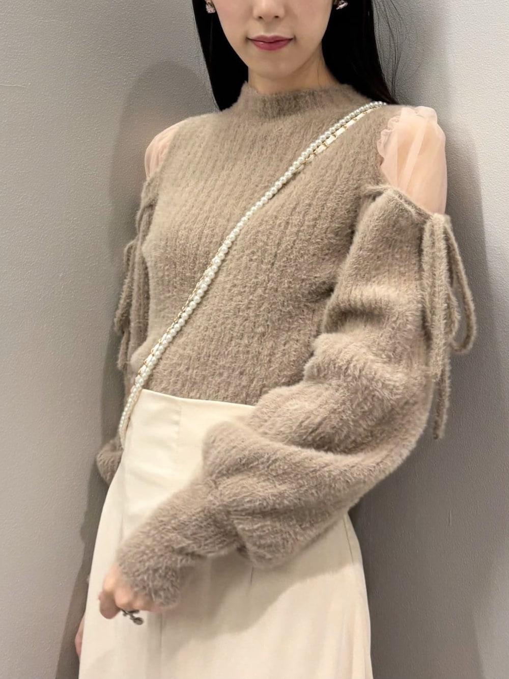 ピンク系のニット/セーター、ホワイト系のスカートを着用したレディースの冬コーディネートの3枚目の写真