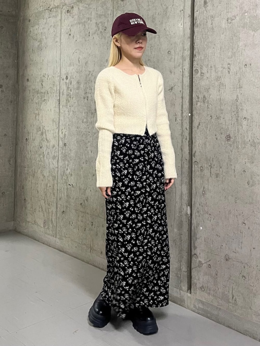 ホワイト系のニット/セーター、ブラック系のスカートを着用したレディースの冬コーディネートの2枚目の写真