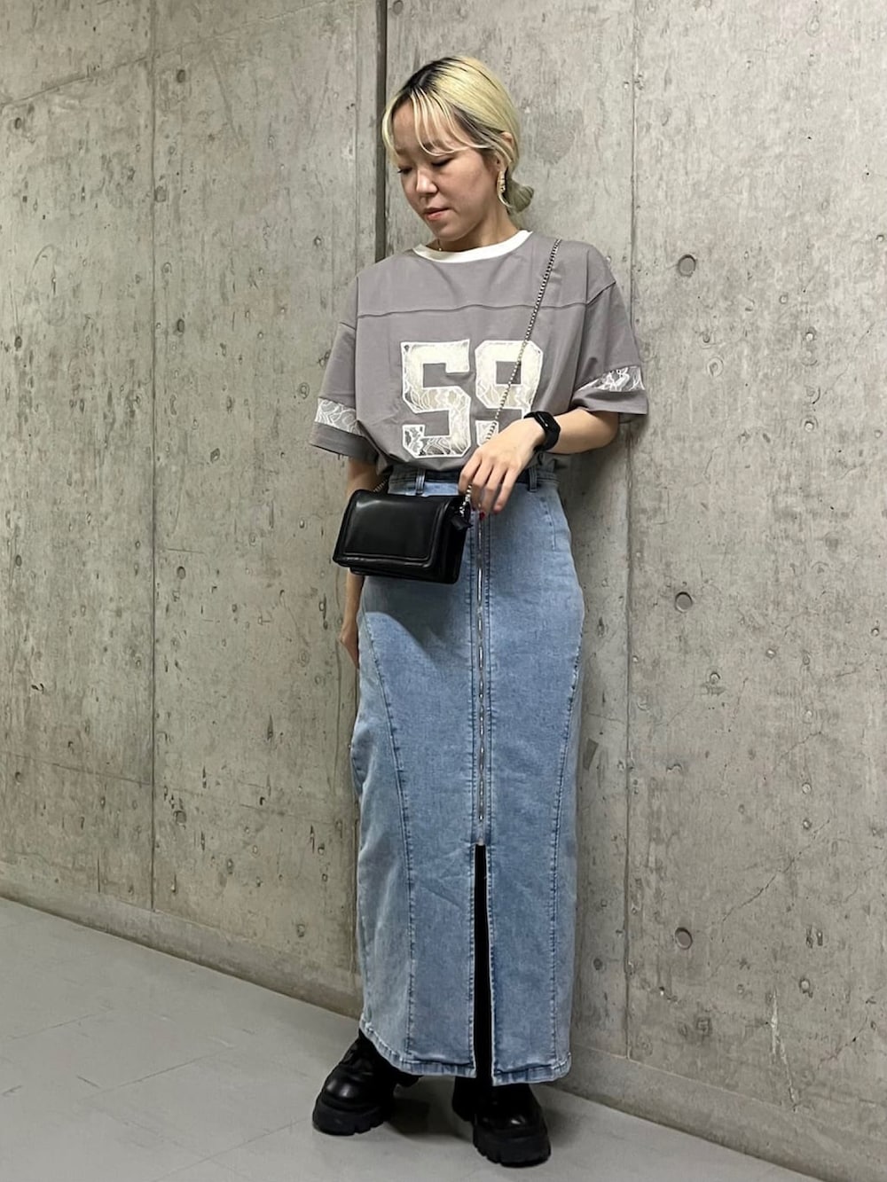 グレー系のTシャツ/カットソー、ブルー系のデニムスカート、ブラック系のショルダーバッグを着用したレディースの夏コーディネートの2枚目の写真