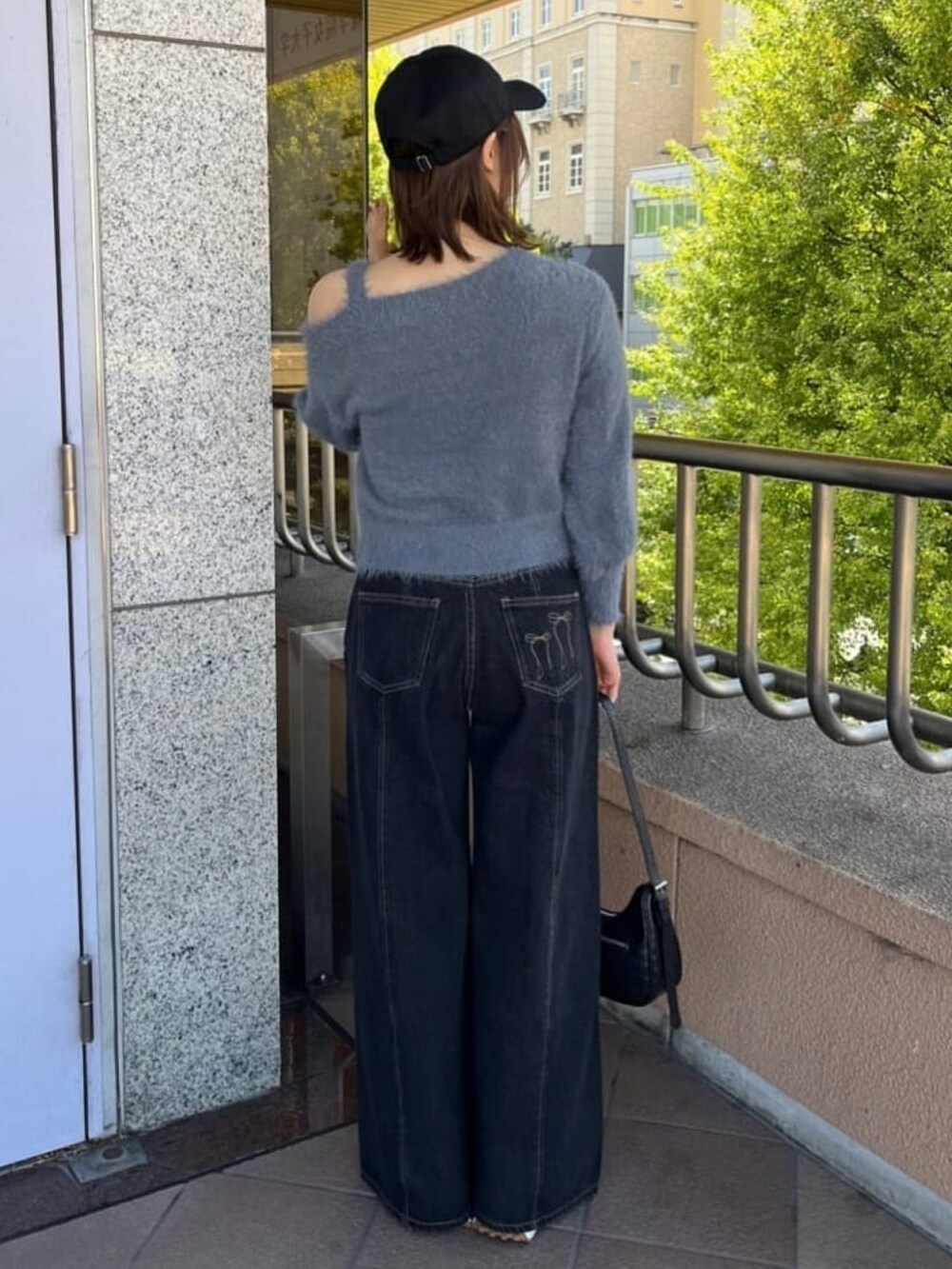 グレー系のニット/セーター、ブルー系のデニムパンツを着用したレディースの秋コーディネートの3枚目の写真