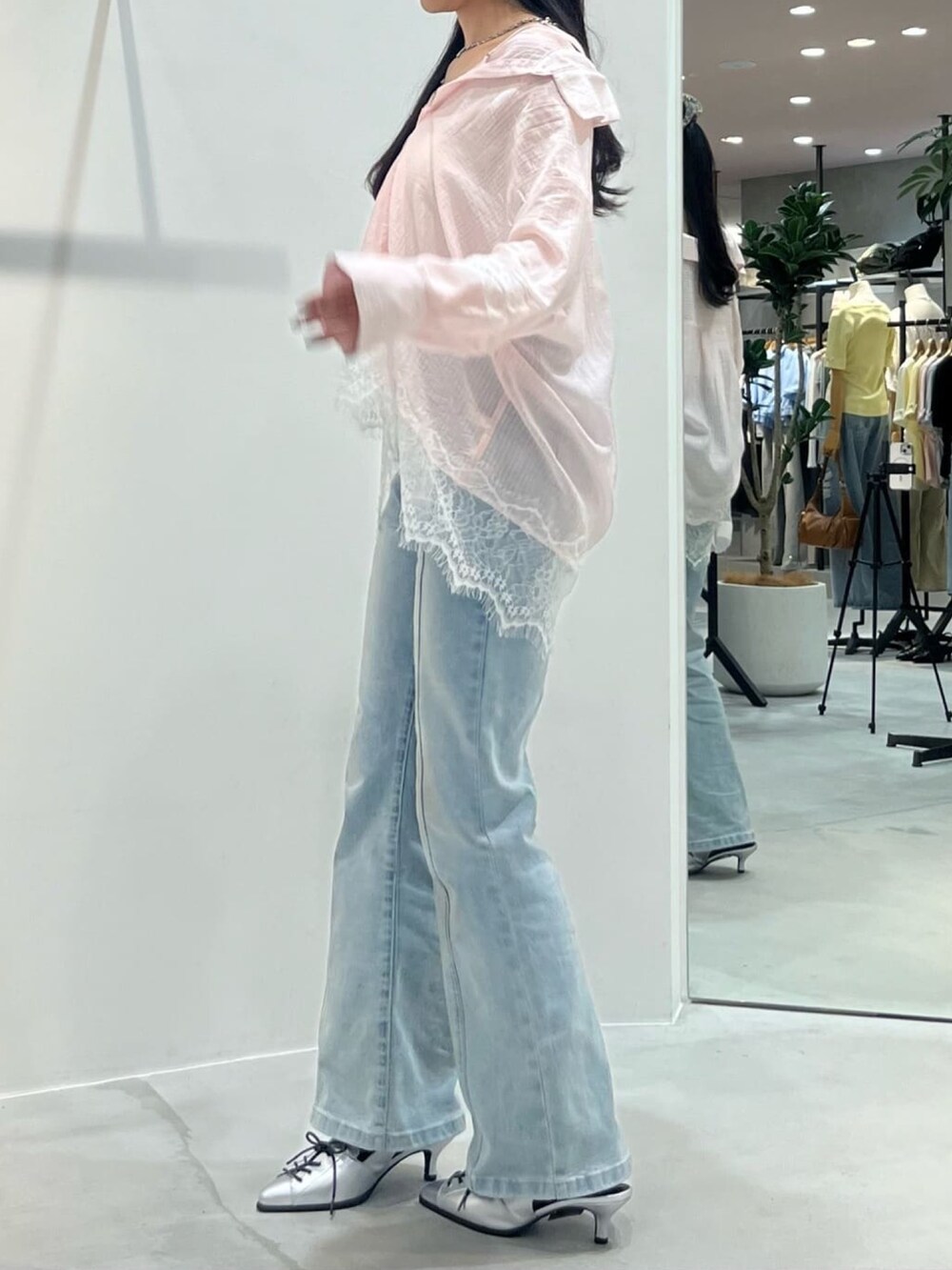 ピンク系のシャツ/ブラウス、ブルー系のデニムパンツを着用したレディースの春コーディネートの2枚目の写真