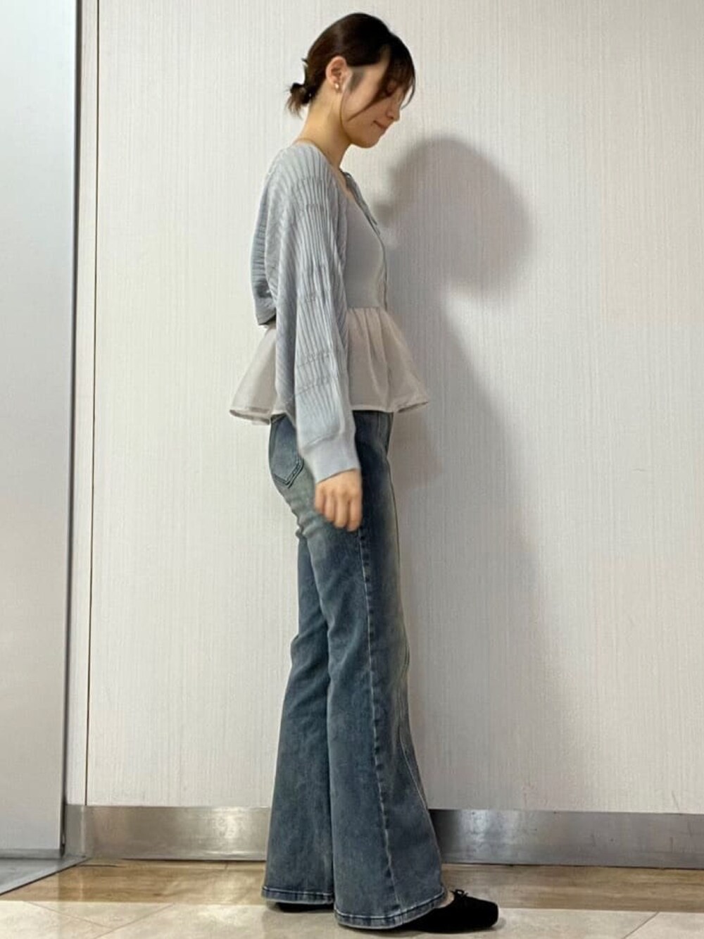 ブルー系のデニムパンツ、グレー系のアンサンブルを着用したレディースの秋コーディネートの2枚目の写真