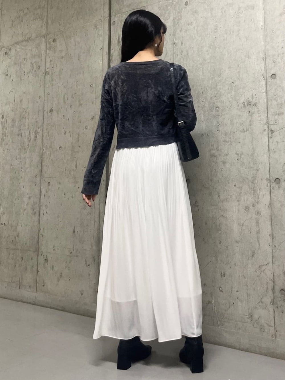 グレー系のカーディガン/ボレロ、ホワイト系のスカートを着用したレディースの秋コーディネートの3枚目の写真
