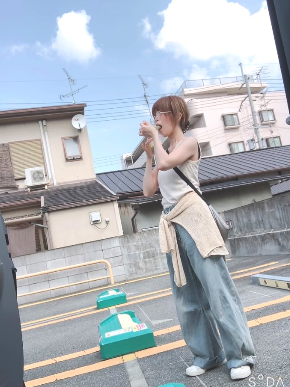 ブルー系のデニムパンツを着用したレディースの夏コーディネートの2枚目の写真