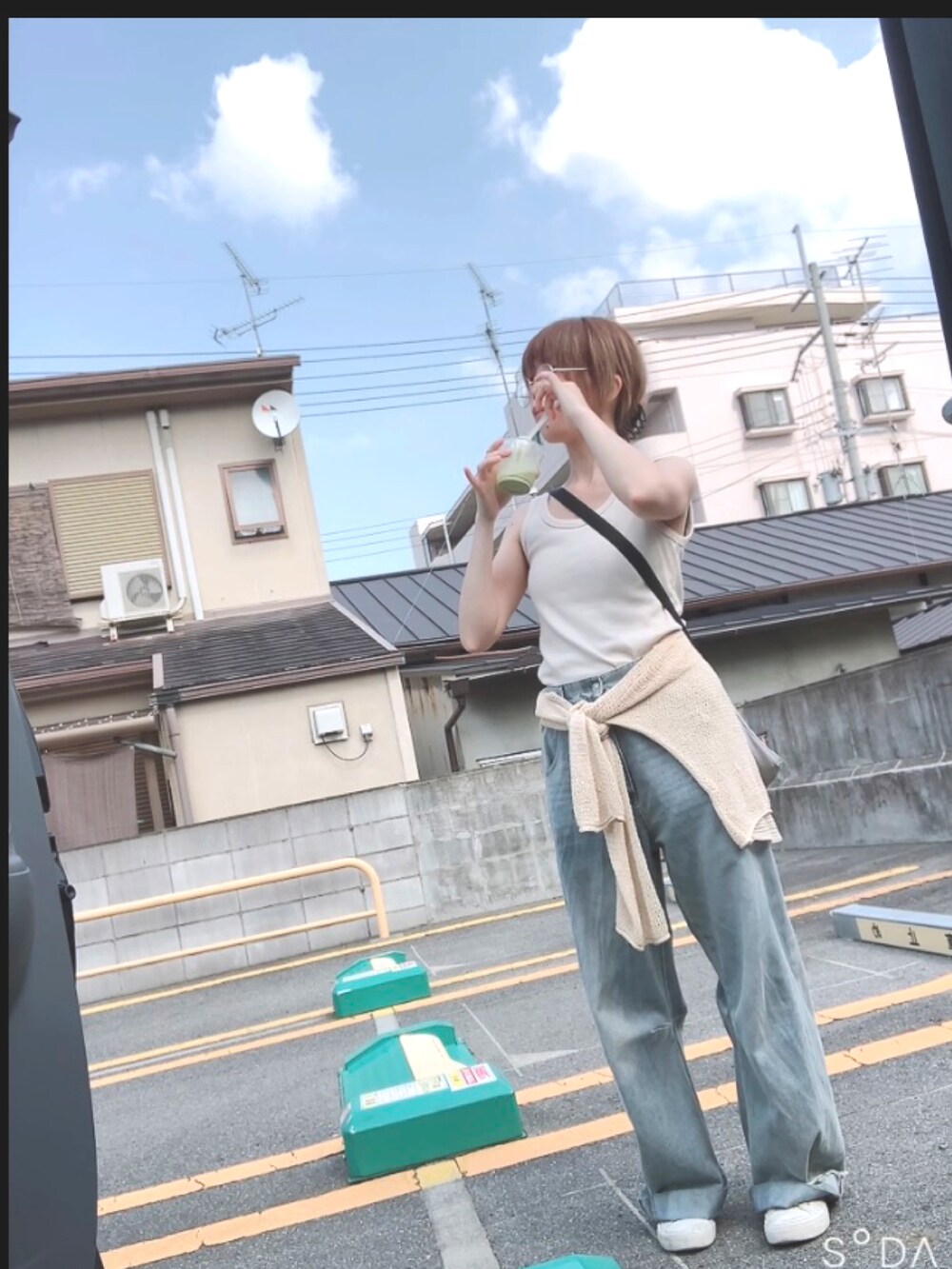 ブルー系のデニムパンツを着用したレディースの夏コーディネートの3枚目の写真