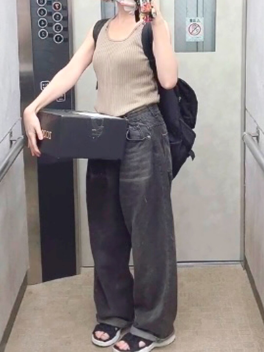 ブラック系のデニムパンツを着用したレディースの夏コーディネートの2枚目の写真