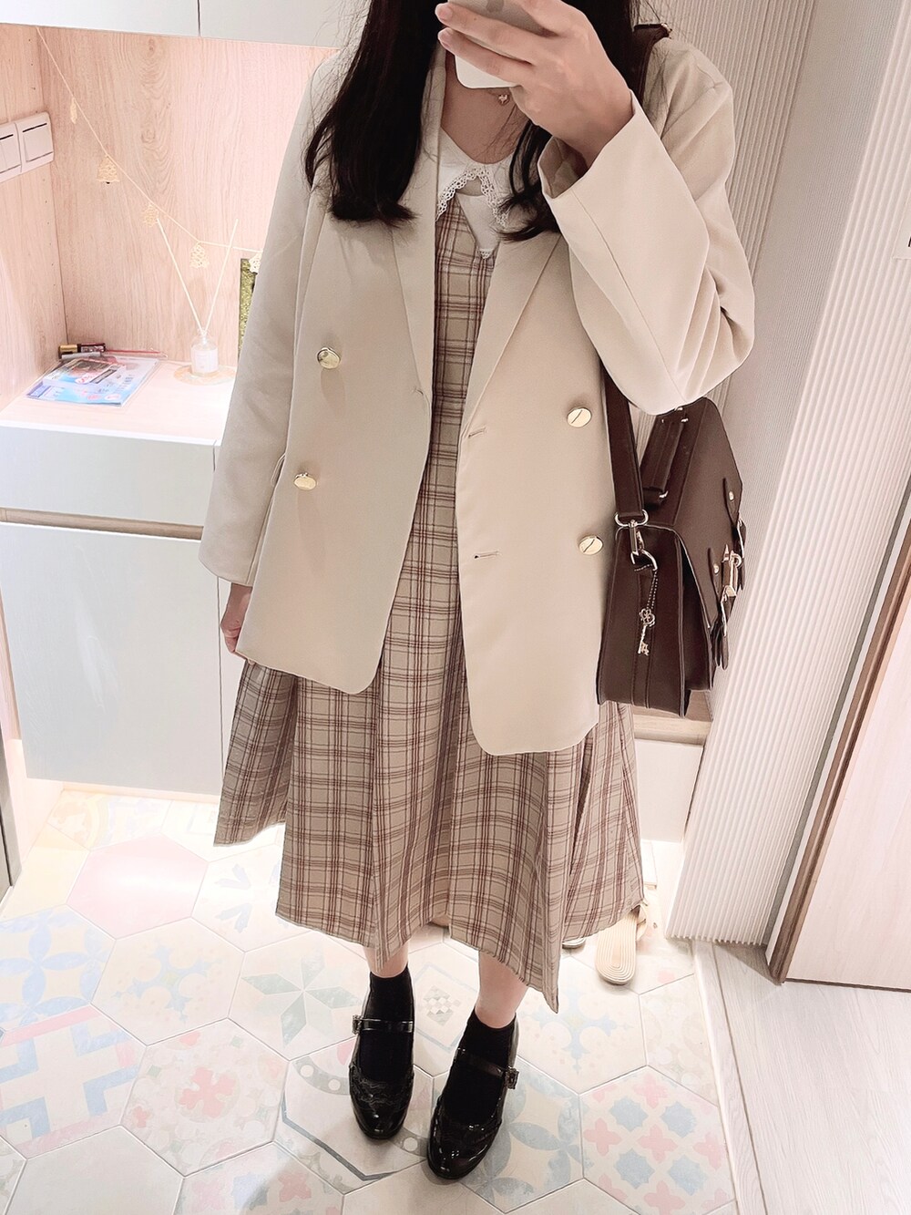 ベージュ系のジャンパースカート、ブラウン系のバックパック/リュック、ブラック系のその他シューズを着用したレディースの秋コーディネートの3枚目の写真