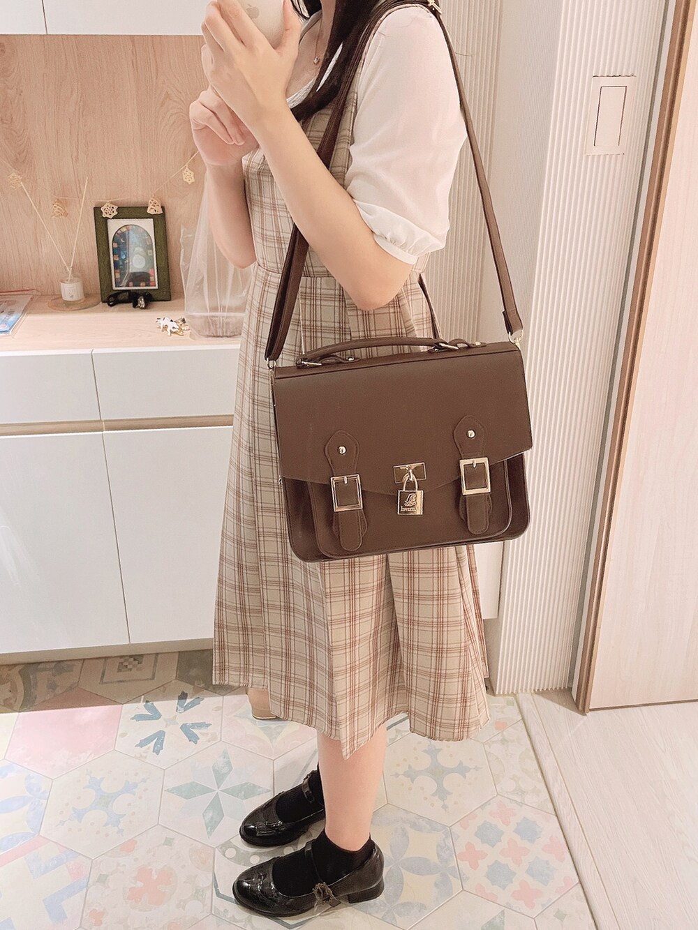 ベージュ系のジャンパースカート、ブラウン系のバックパック/リュック、ブラック系のその他シューズを着用したレディースの秋コーディネートの2枚目の写真