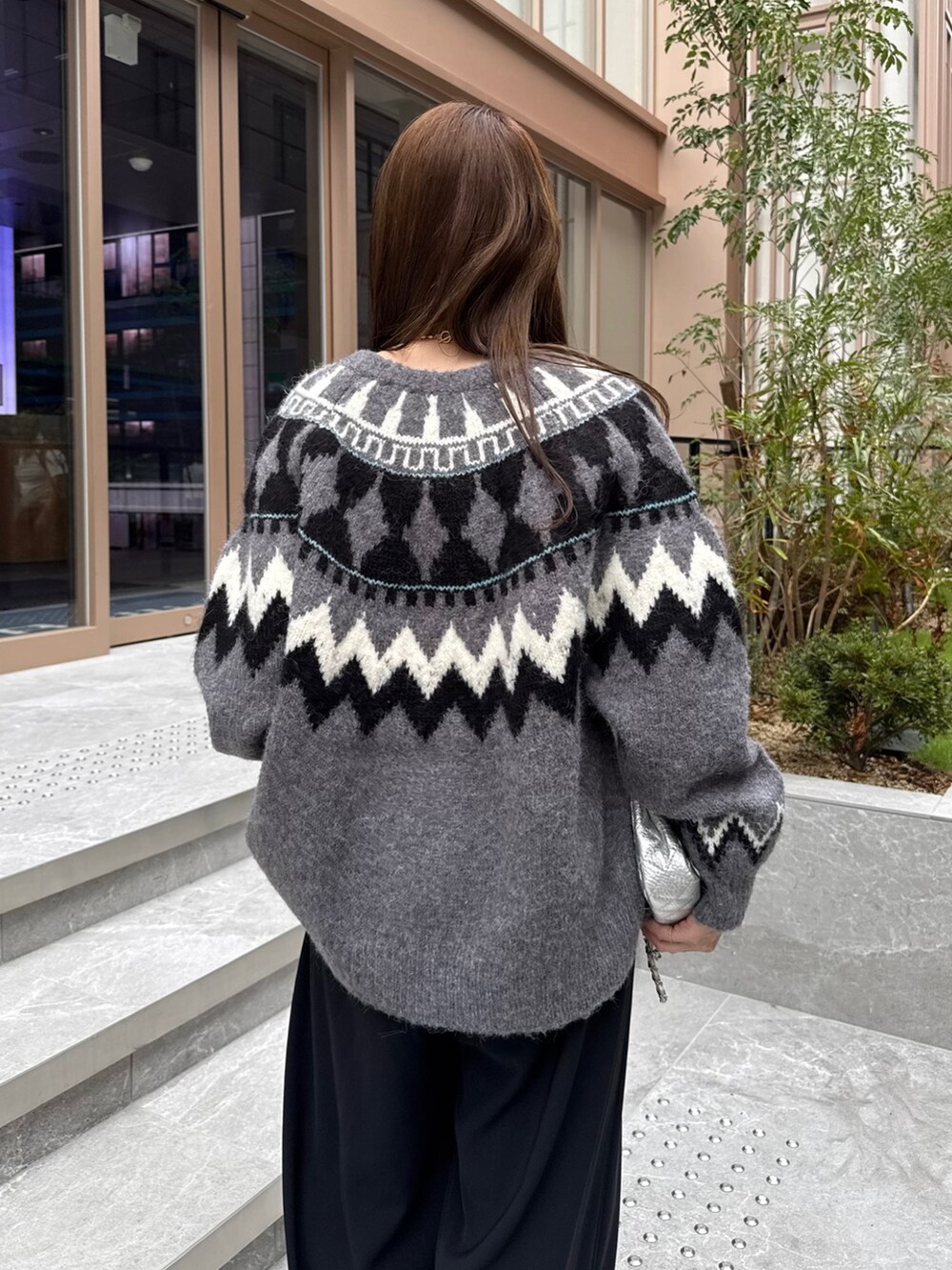 ブラック系のスラックス、グレー系のカーディガン/ボレロ、シルバー系のショルダーバッグを着用したレディースの秋コーディネートの6枚目の写真