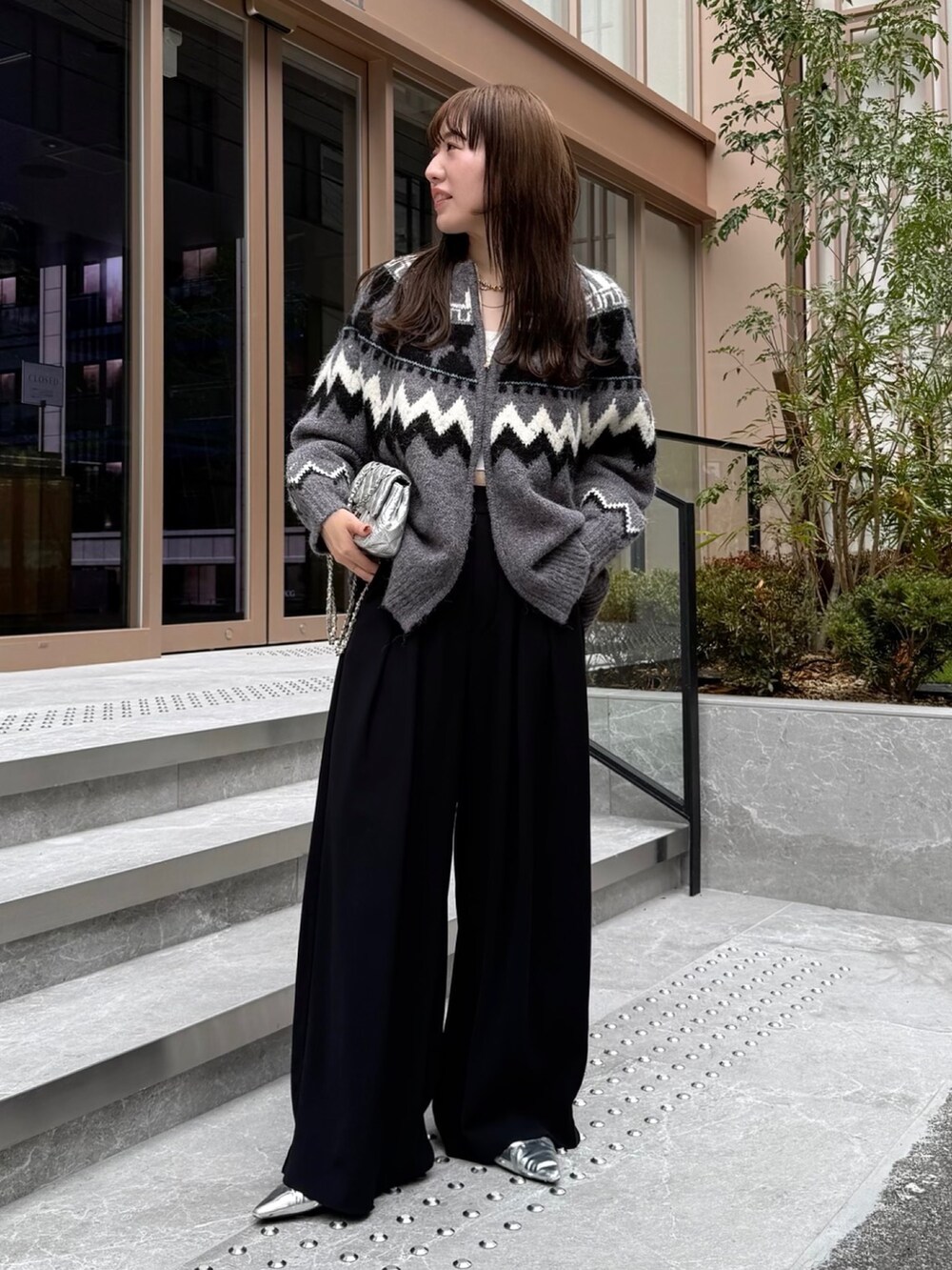 ブラック系のスラックス、グレー系のカーディガン/ボレロ、シルバー系のショルダーバッグを着用したレディースの秋コーディネートの9枚目の写真