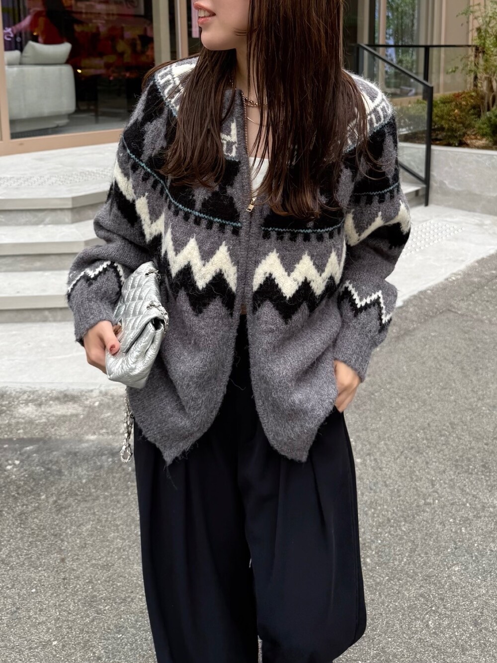 ブラック系のスラックス、グレー系のカーディガン/ボレロ、シルバー系のショルダーバッグを着用したレディースの秋コーディネートの8枚目の写真