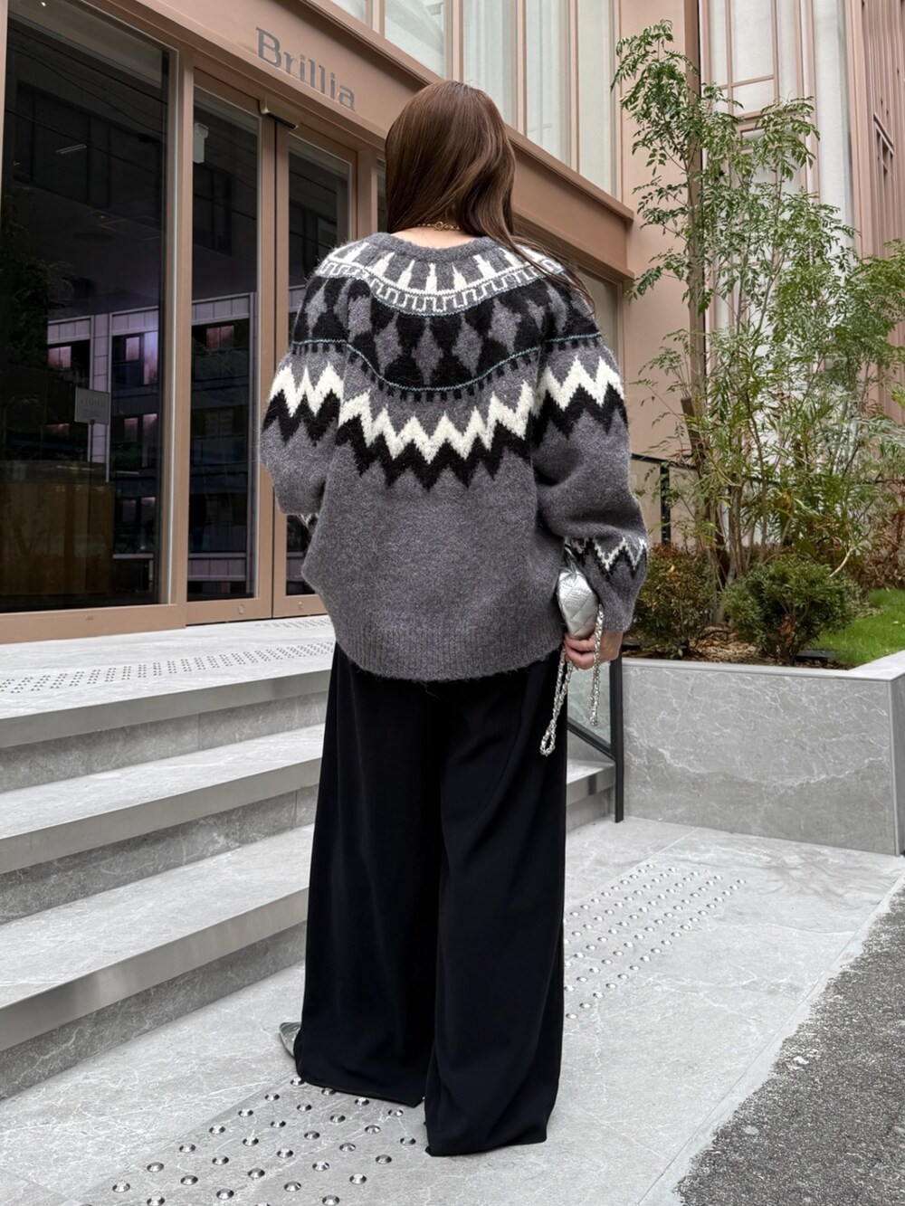 ブラック系のスラックス、グレー系のカーディガン/ボレロ、シルバー系のショルダーバッグを着用したレディースの秋コーディネートの3枚目の写真