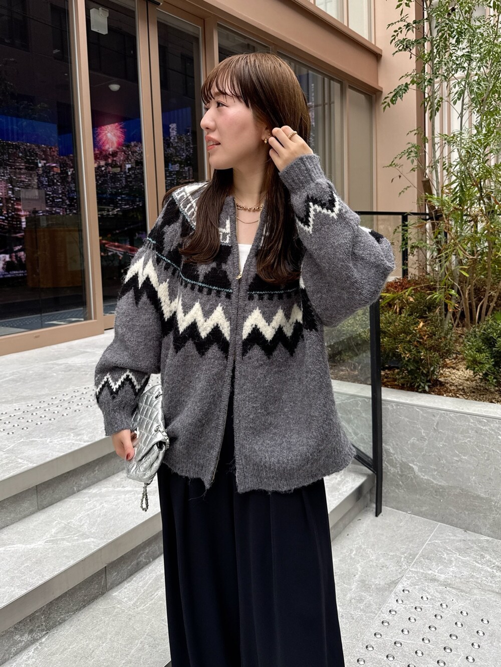 ブラック系のスラックス、グレー系のカーディガン/ボレロ、シルバー系のショルダーバッグを着用したレディースの秋コーディネートの7枚目の写真