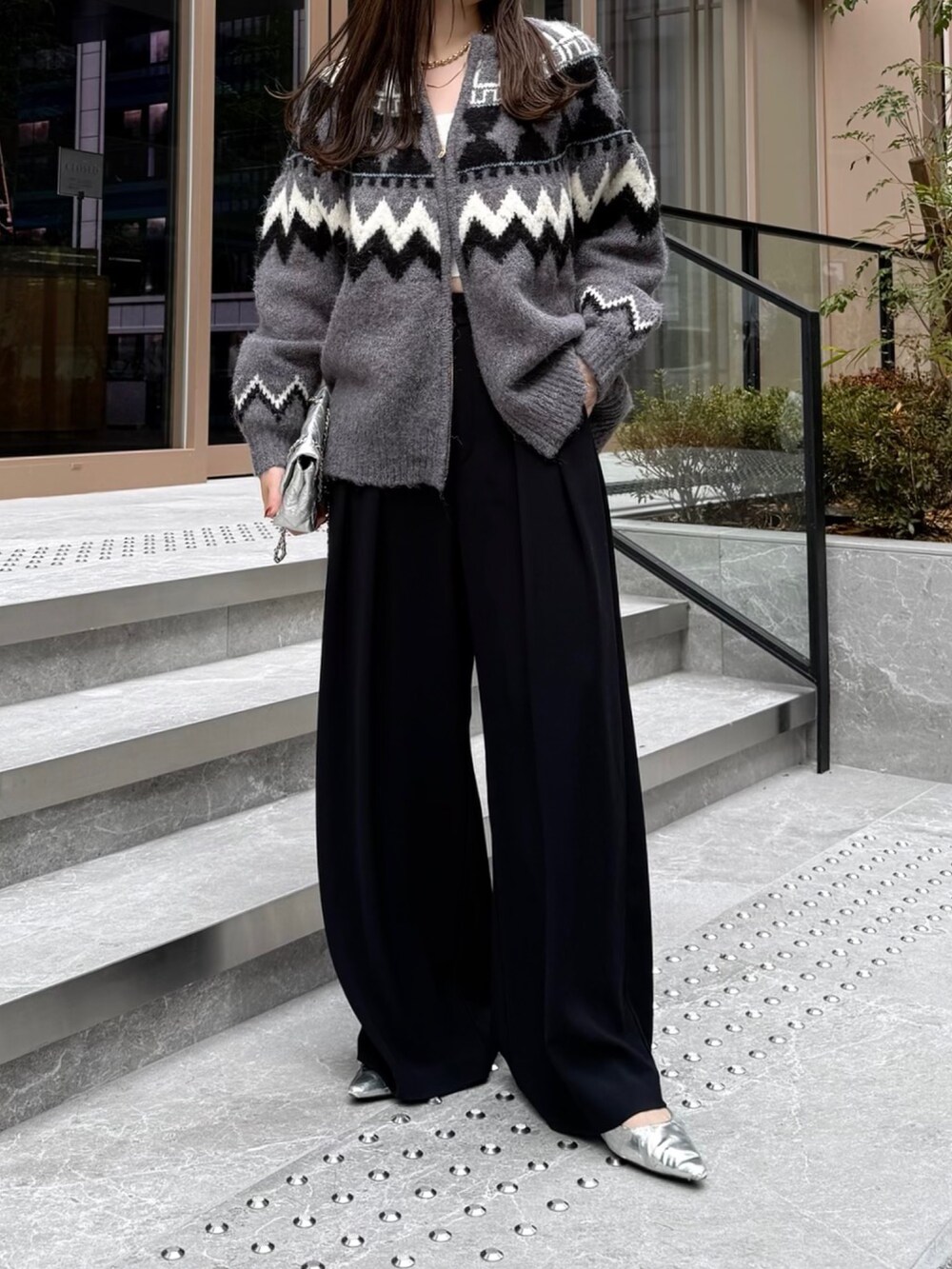 ブラック系のスラックス、グレー系のカーディガン/ボレロ、シルバー系のショルダーバッグを着用したレディースの秋コーディネートの2枚目の写真