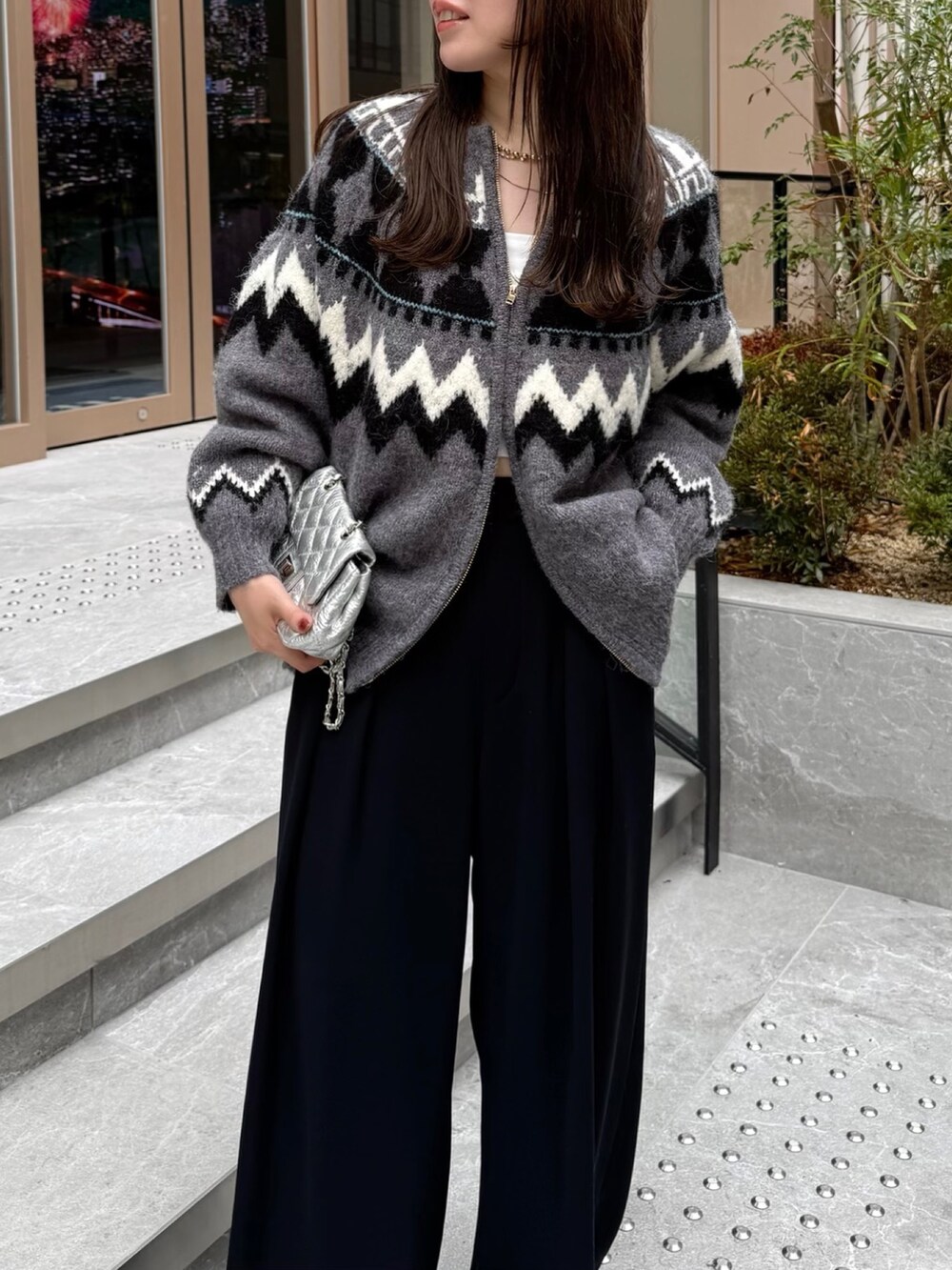 ブラック系のスラックス、グレー系のカーディガン/ボレロ、シルバー系のショルダーバッグを着用したレディースの秋コーディネートの4枚目の写真