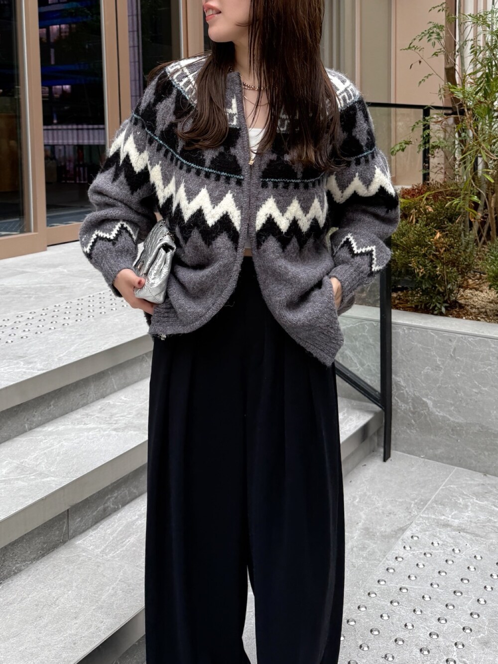 ブラック系のスラックス、グレー系のカーディガン/ボレロ、シルバー系のショルダーバッグを着用したレディースの秋コーディネートの10枚目の写真