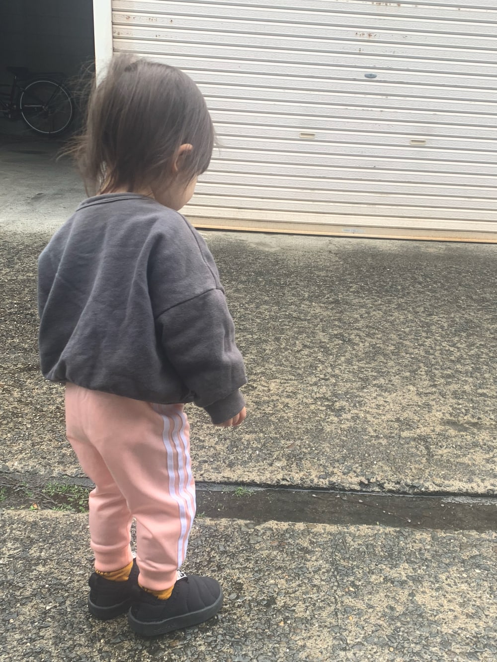 ピンク系のパンツ、ブラック系のその他シューズ、グレー系のスウェットを着用したキッズの冬コーディネートの2枚目の写真