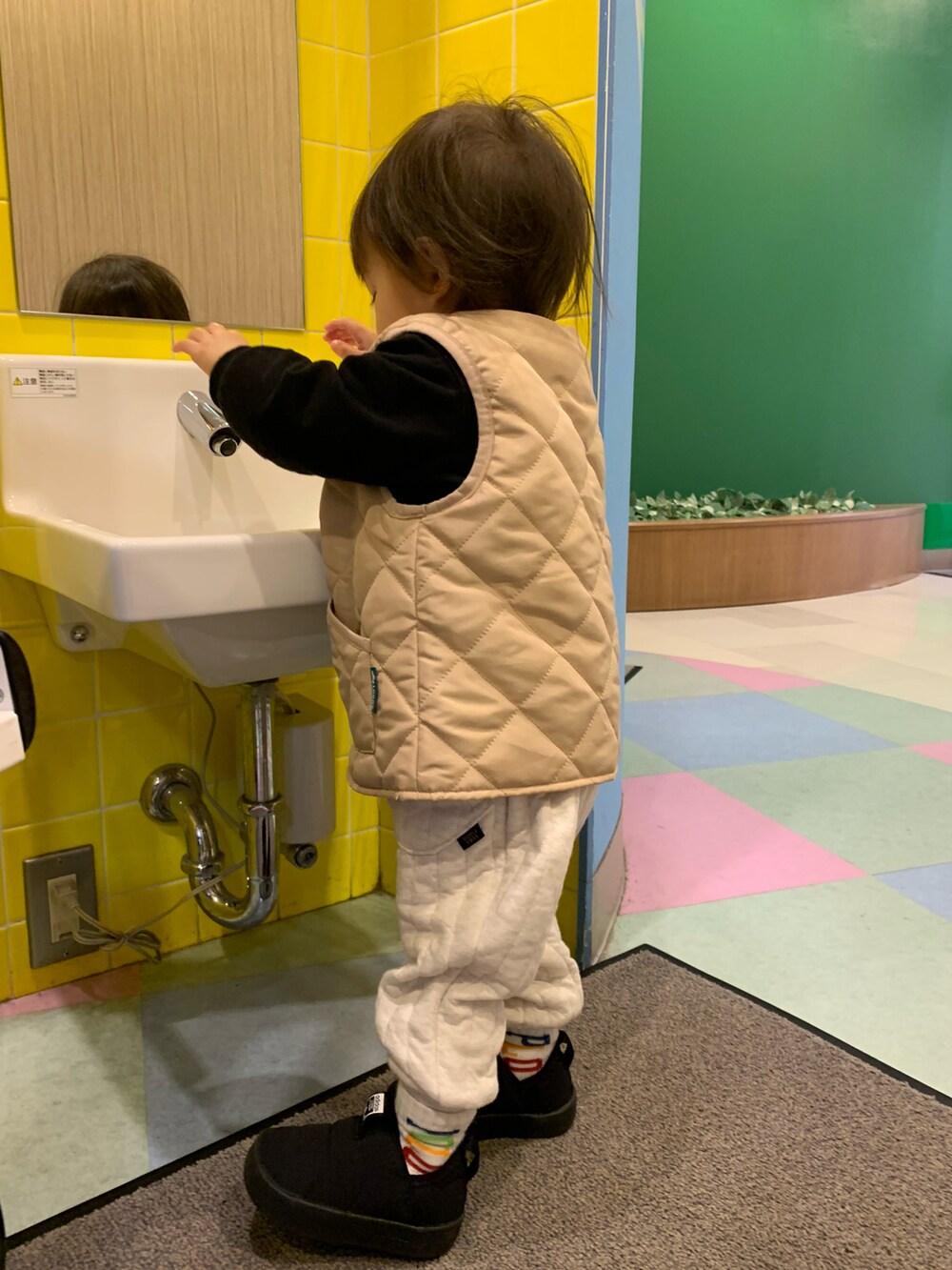 ブラック系のスウェット、ホワイト系のパンツ、ブラック系のその他シューズを着用したキッズの秋コーディネートの2枚目の写真