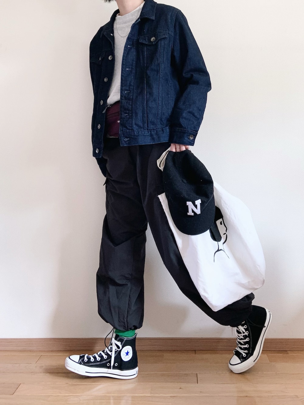 グレー系のスウェット、ブルー系のデニムジャケット、パープル系のバッグを着用したレディースの春コーディネートの2枚目の写真