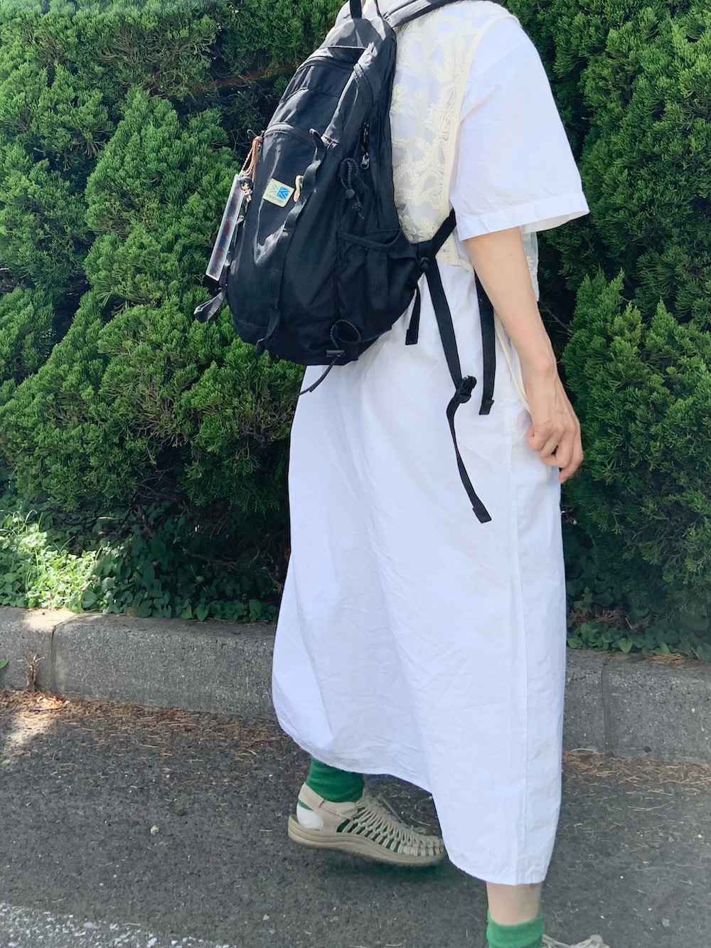 ホワイト系のワンピース、ホワイト系のベスト、ベージュ系のサンダルを着用したレディースの夏コーディネートの2枚目の写真