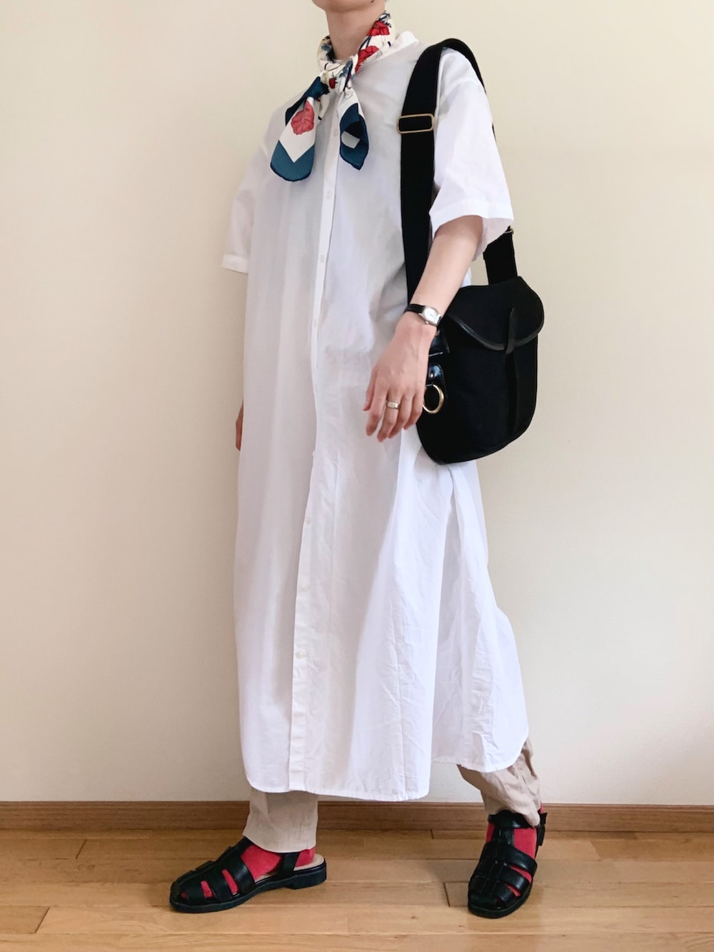 ブラック系のサンダル、ホワイト系のワンピース、ブラック系のショルダーバッグを着用したレディースの秋コーディネートの2枚目の写真