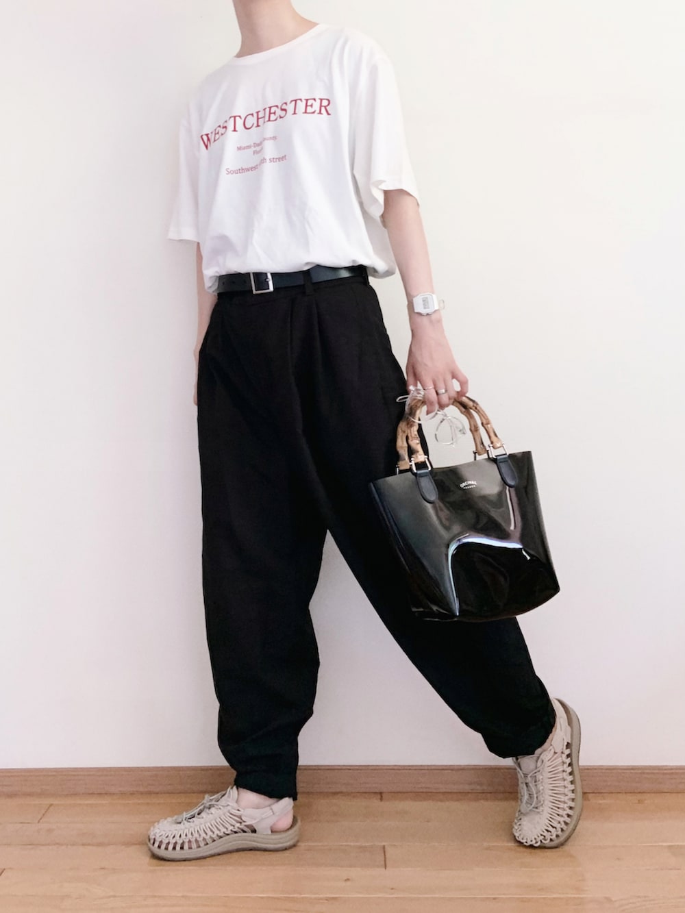 ブラック系のハンドバッグ、ホワイト系のワンピース、ホワイト系のTシャツ/カットソーを着用したレディースの夏コーディネートの3枚目の写真