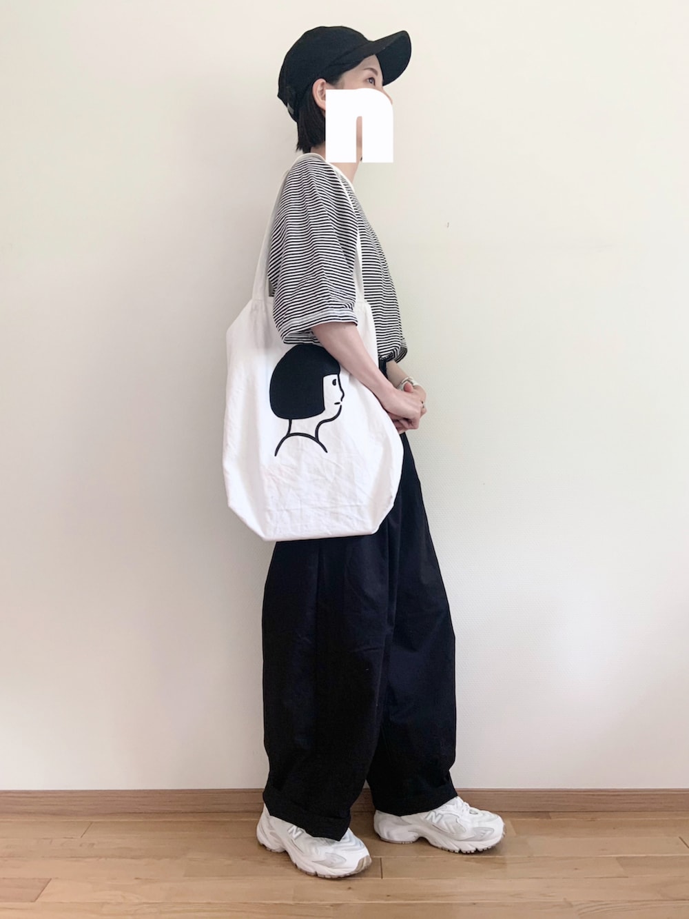 ブラック系のその他パンツ、ホワイト系のTシャツ/カットソー、ホワイト系のトートバッグを着用したレディースの春コーディネートの2枚目の写真