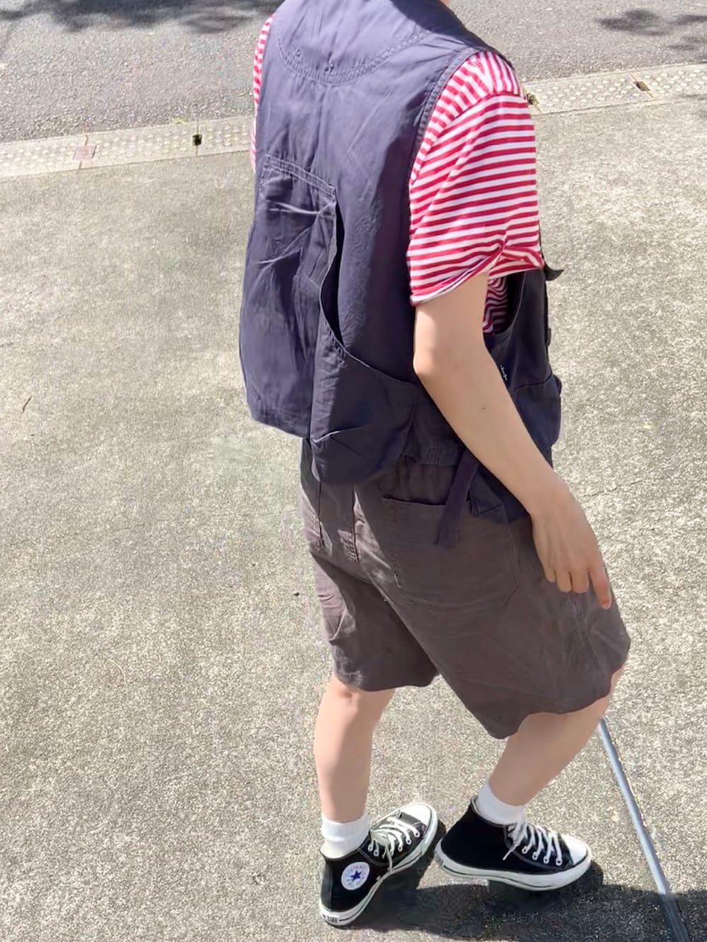 ブラック系のスニーカー、グレー系のその他パンツ、グレー系のベストを着用したレディースの夏コーディネートの3枚目の写真