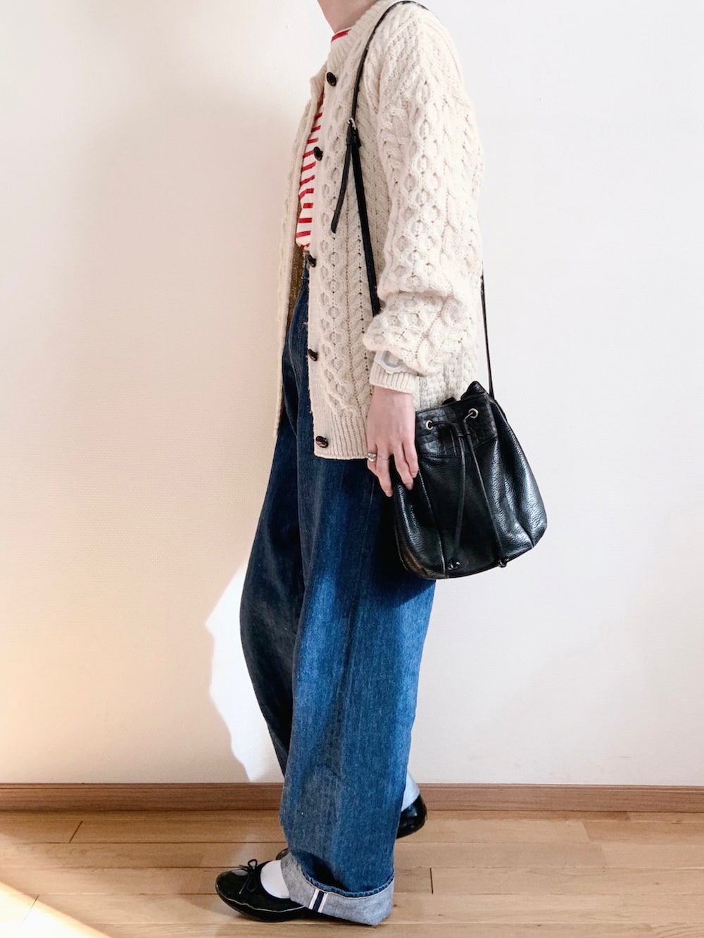 ホワイト系のカーディガン/ボレロ、レッド系のTシャツ/カットソー、ブルー系のデニムパンツを着用したレディースの秋コーディネートの3枚目の写真