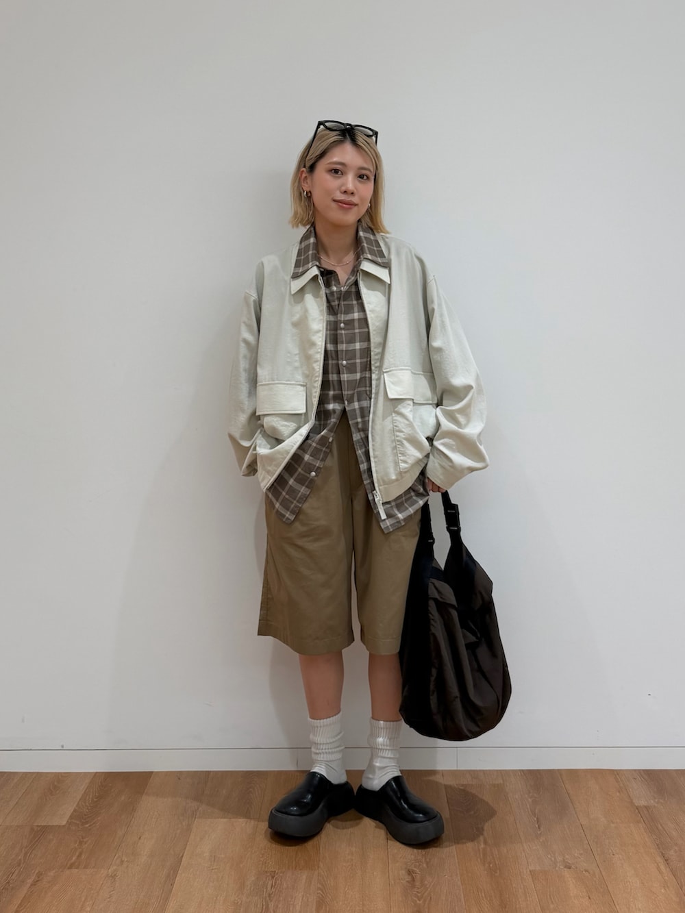 ブラック系のサンダル、ホワイト系のブルゾン、ブラウン系のシャツ/ブラウスを着用したレディースの春コーディネートの3枚目の写真