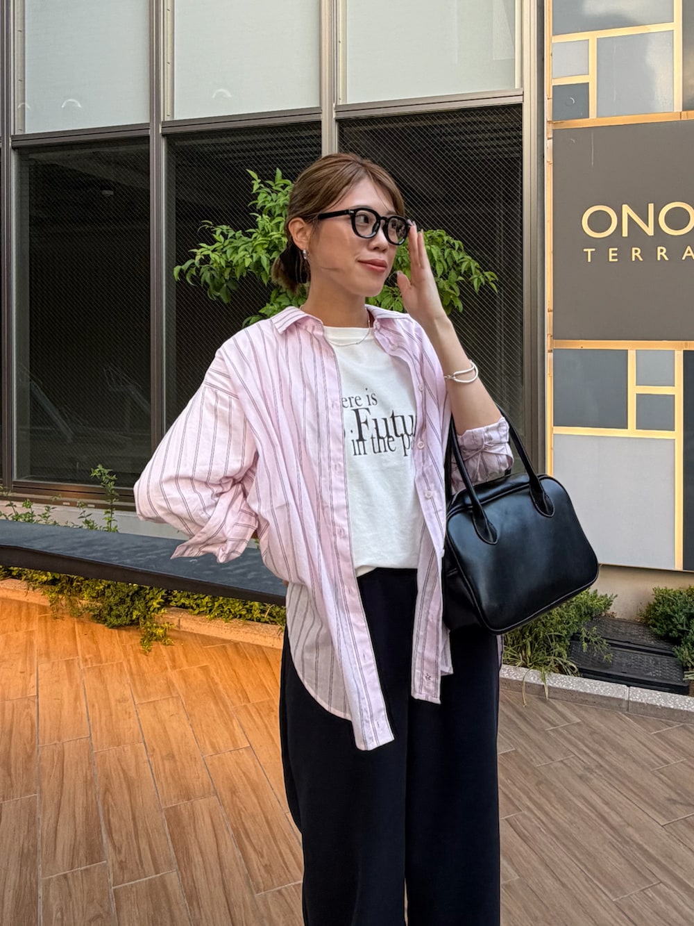 ブラック系のボストンバッグ、ホワイト系のTシャツ/カットソー、ピンク系のシャツ/ブラウスを着用したレディースの春コーディネートの3枚目の写真