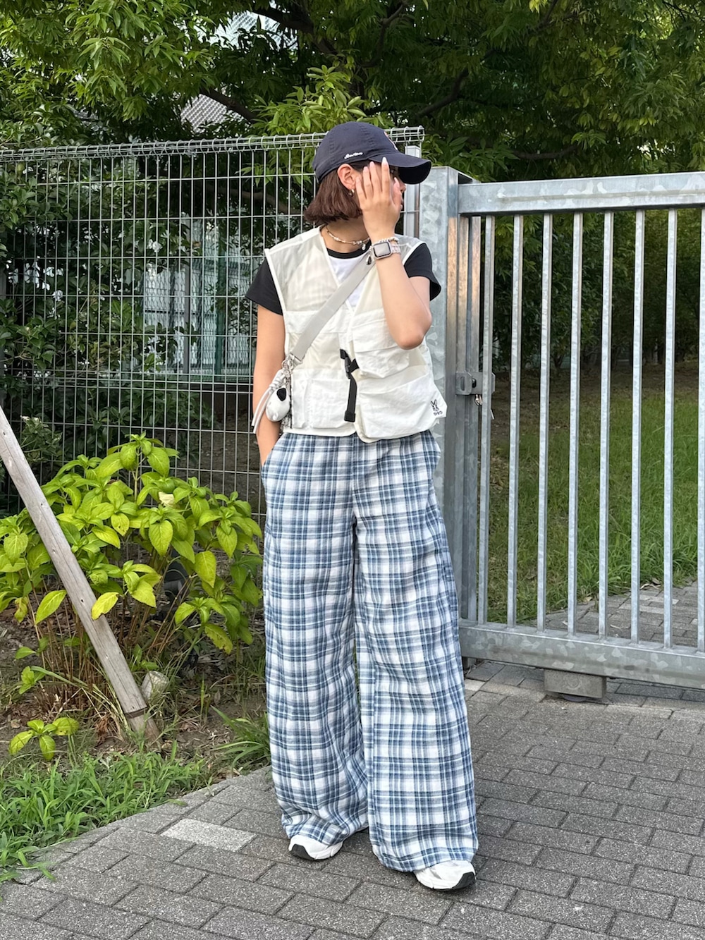 グレー系のショルダーバッグ、ブルー系のその他パンツ、ホワイト系のベストを着用したレディースの夏コーディネートの2枚目の写真