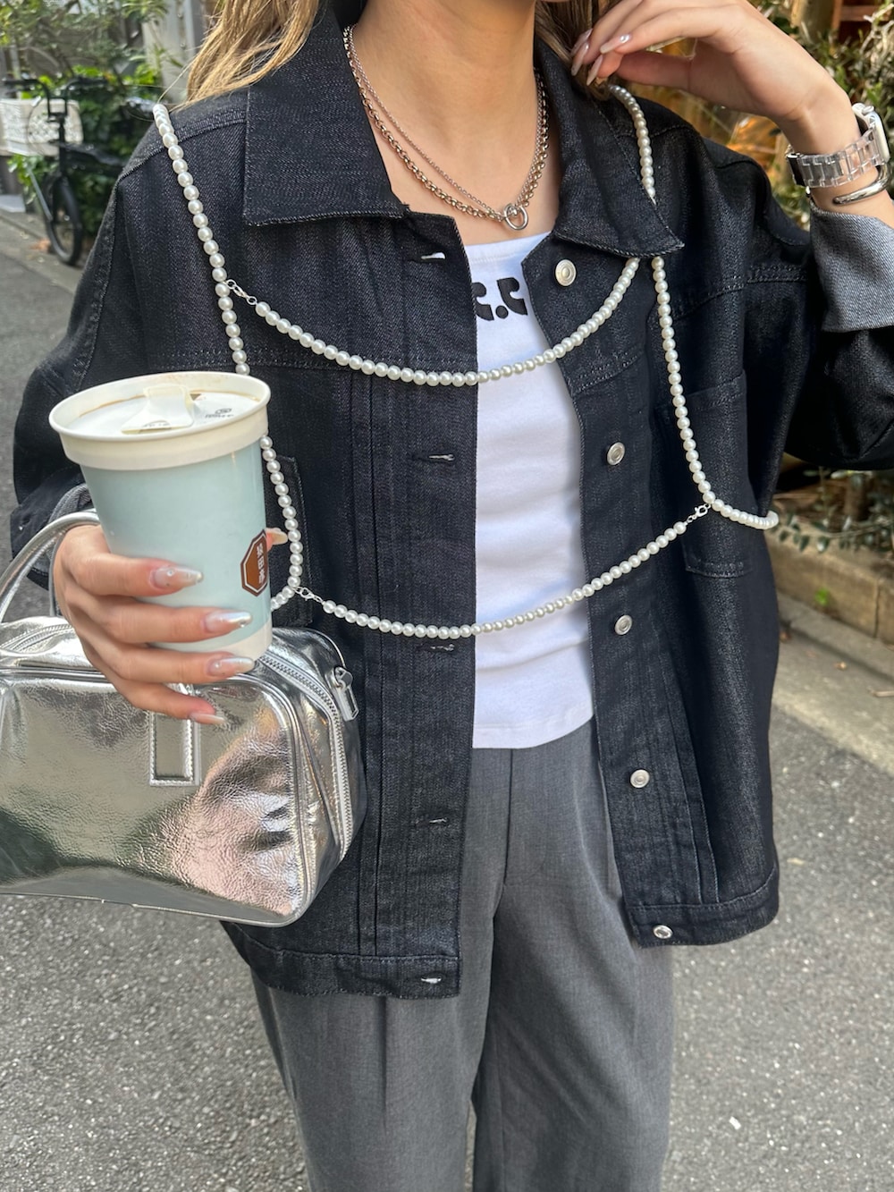 ホワイト系のスニーカー、グレー系のスラックス、シルバー系のボストンバッグを着用したレディースの春コーディネートの3枚目の写真