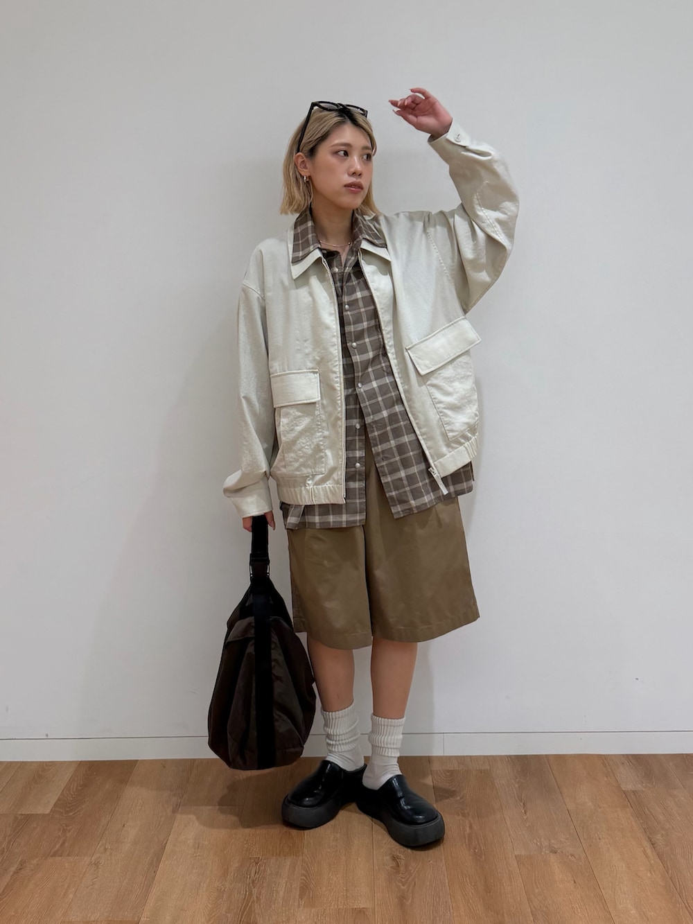 ブラック系のサンダル、ホワイト系のブルゾン、ブラウン系のシャツ/ブラウスを着用したレディースの春コーディネートの4枚目の写真