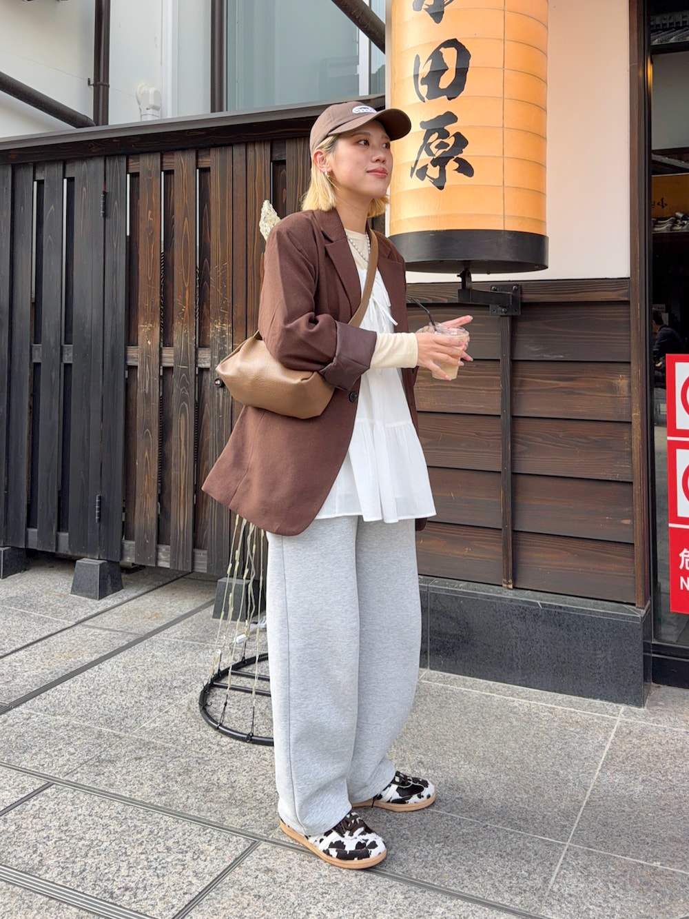 グレー系のスウェットパンツ、ブラウン系のスニーカー、ブラウン系のテーラードジャケットを着用したレディースの春コーディネートの2枚目の写真