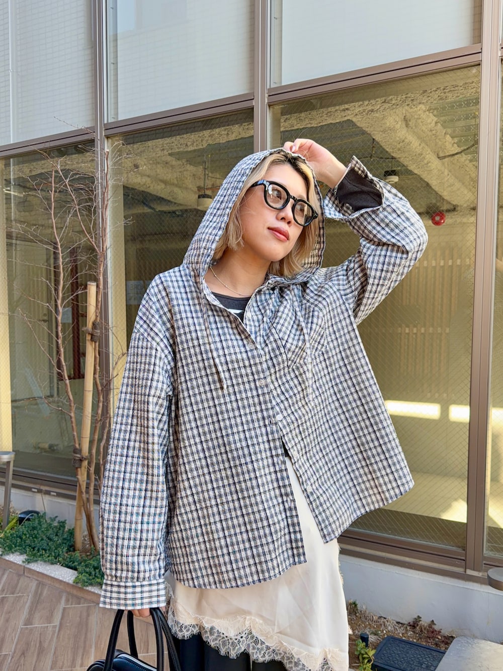 ブルー系のシャツ/ブラウス、グレー系のTシャツ/カットソー、ブラック系のボストンバッグを着用したレディースの春コーディネートの4枚目の写真