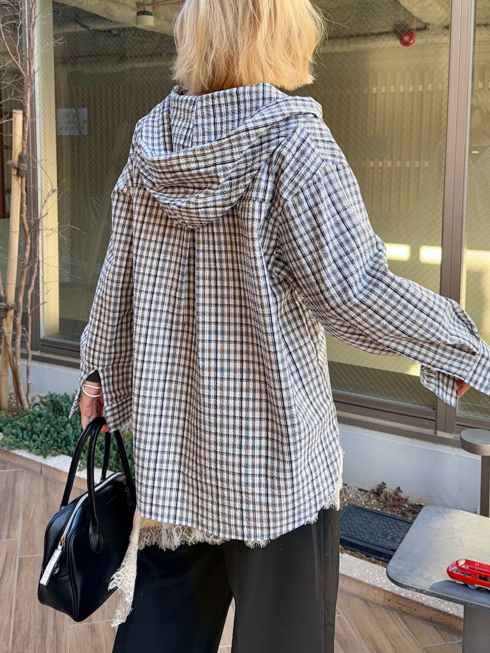 ブルー系のシャツ/ブラウス、グレー系のTシャツ/カットソー、ブラック系のボストンバッグを着用したレディースの春コーディネートの5枚目の写真