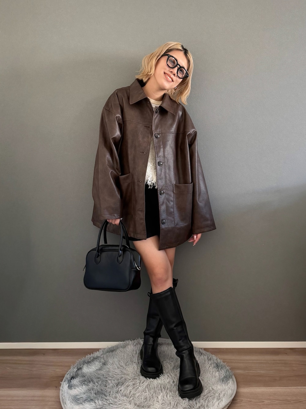 ブラウン系のステンカラーコート、ホワイト系のベスト、ブラック系のその他パンツを着用したレディースの春コーディネートの4枚目の写真